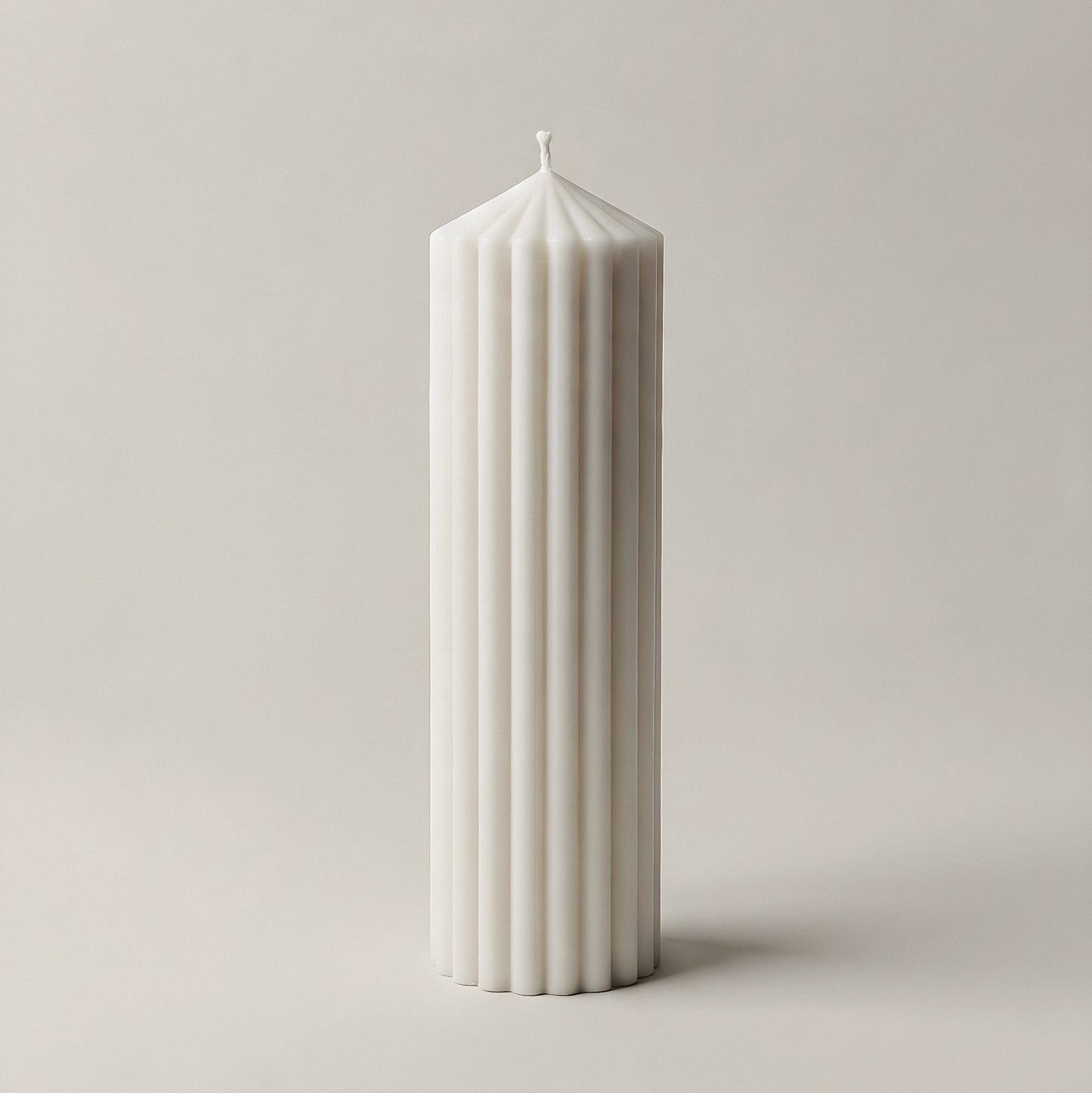 Peak sculptural candle in white soy wax displayed on natural surface with soft lighting detail shot