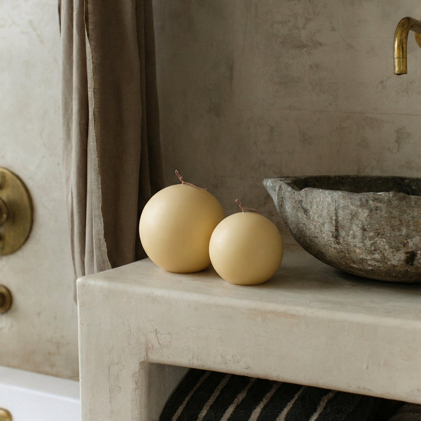 Handmade unscented sphere candle detail showing smooth soy wax texture and sculptural form on neutral surface