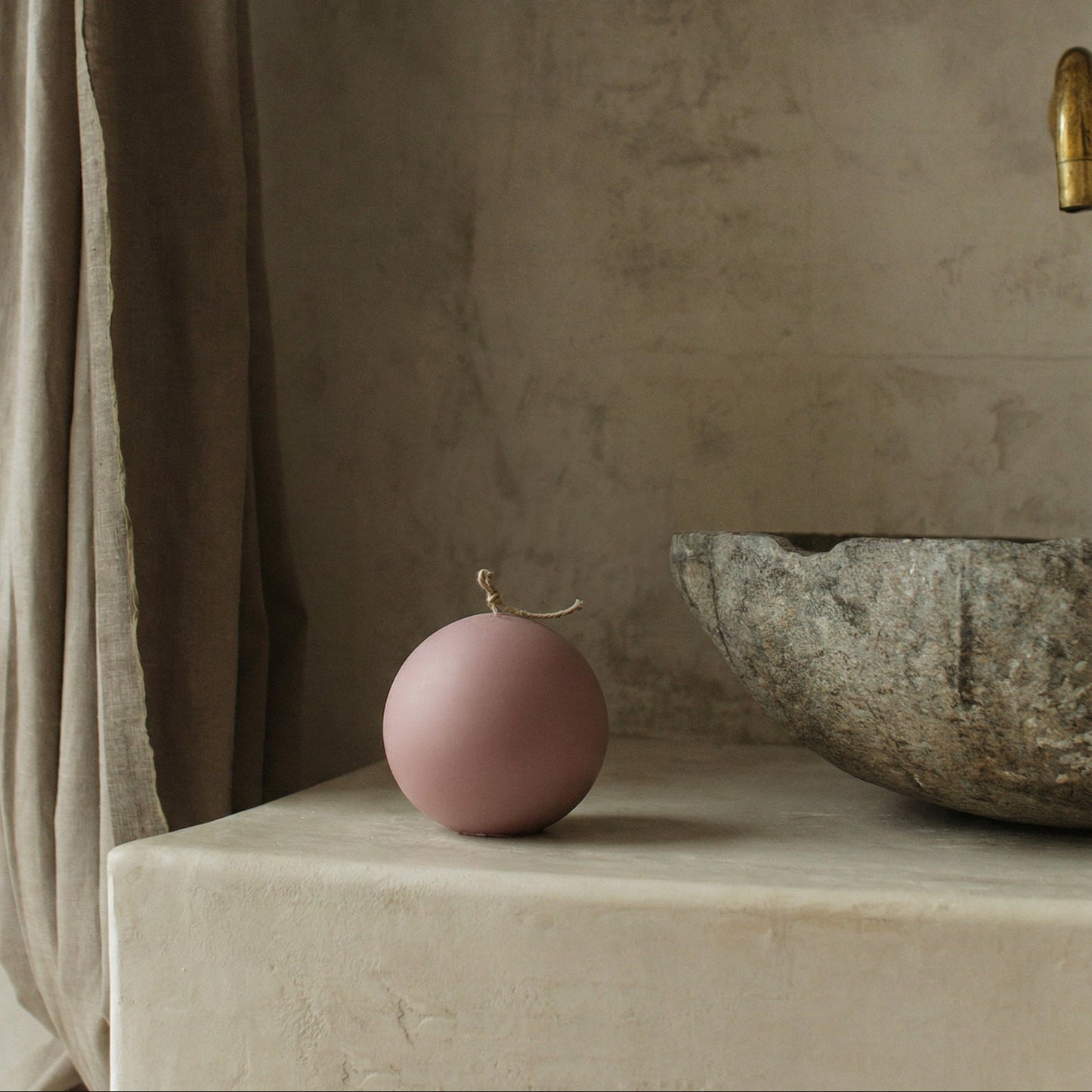 Handmade sculptural sphere candle detail showing smooth soy wax texture in minimalist Los Angeles studio setting