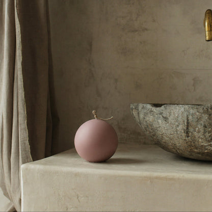 Handmade sculptural sphere candle detail showing smooth soy wax texture in minimalist Los Angeles studio setting