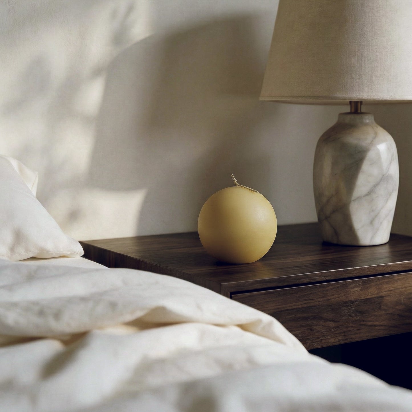 Handmade sphere sculptural candle detail showing smooth soy wax texture in natural light
