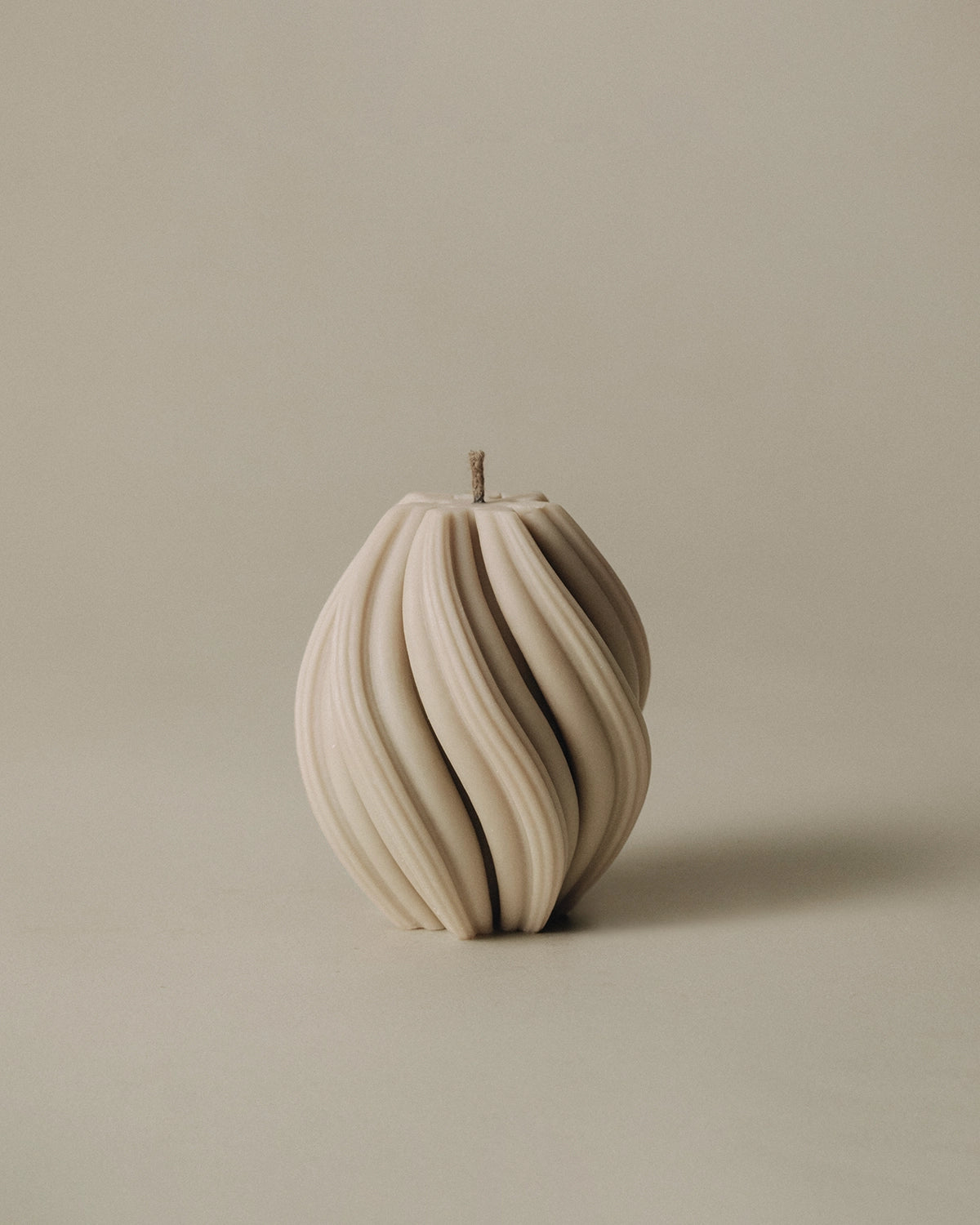LAWA Candles Swirl Candle, small, in Sandstone soy wax with spiraling twisted ridges, product photo on a plain background