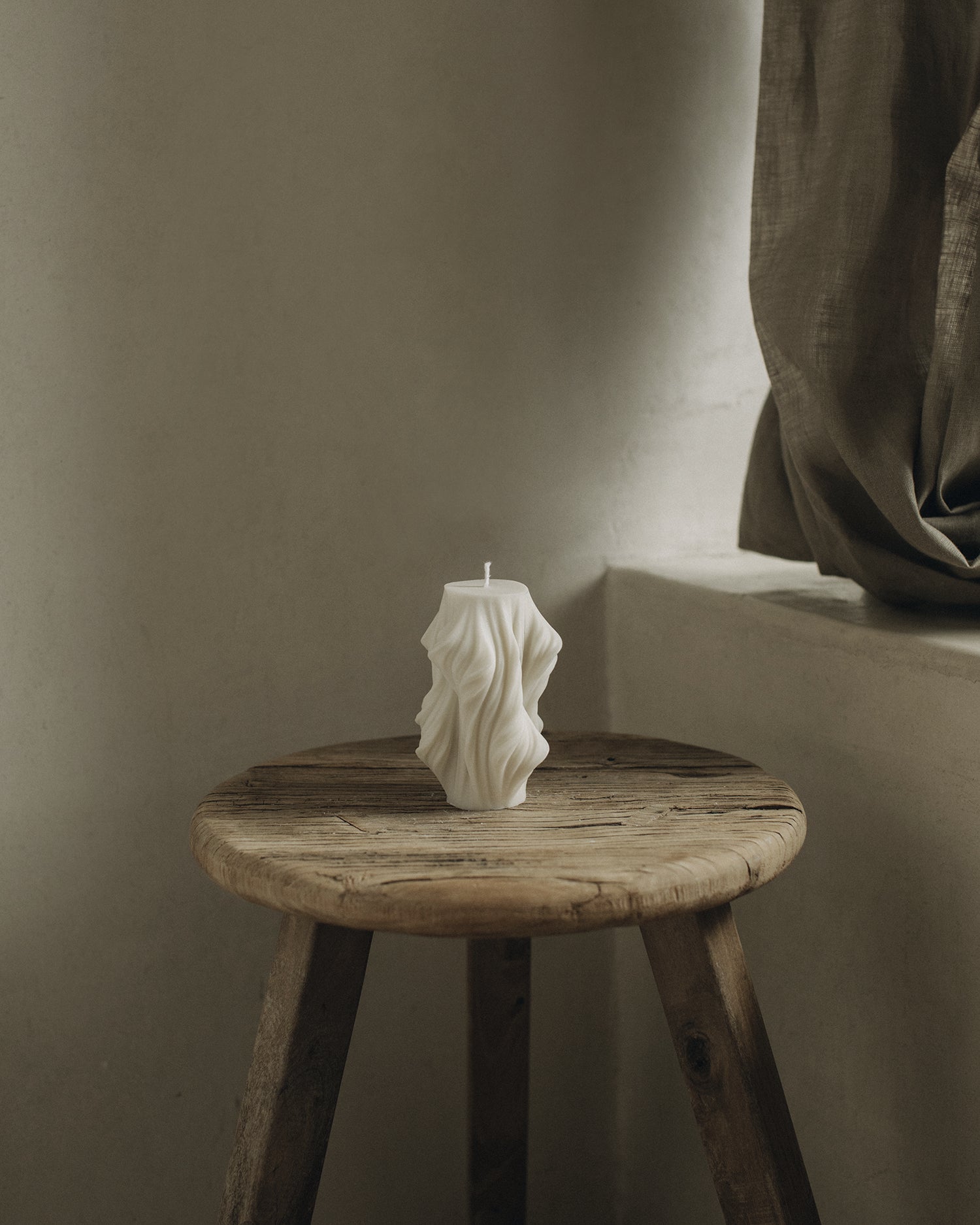 LAWA Candles Cascading Wave Candle, small, in White soy wax styled in a home decor setting