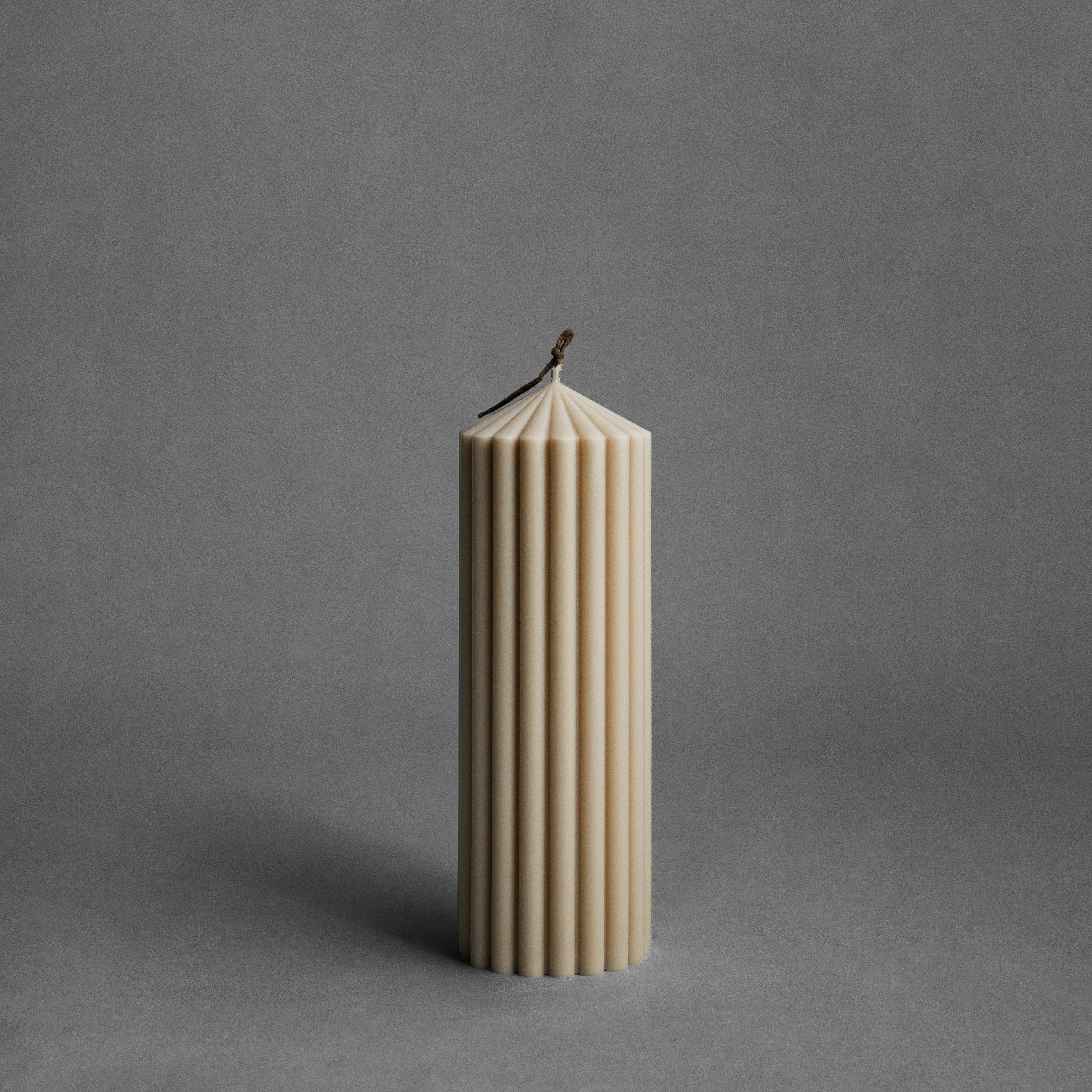 Medium sandstone peak pillar candle by LAWA with tall sculptural pointed form