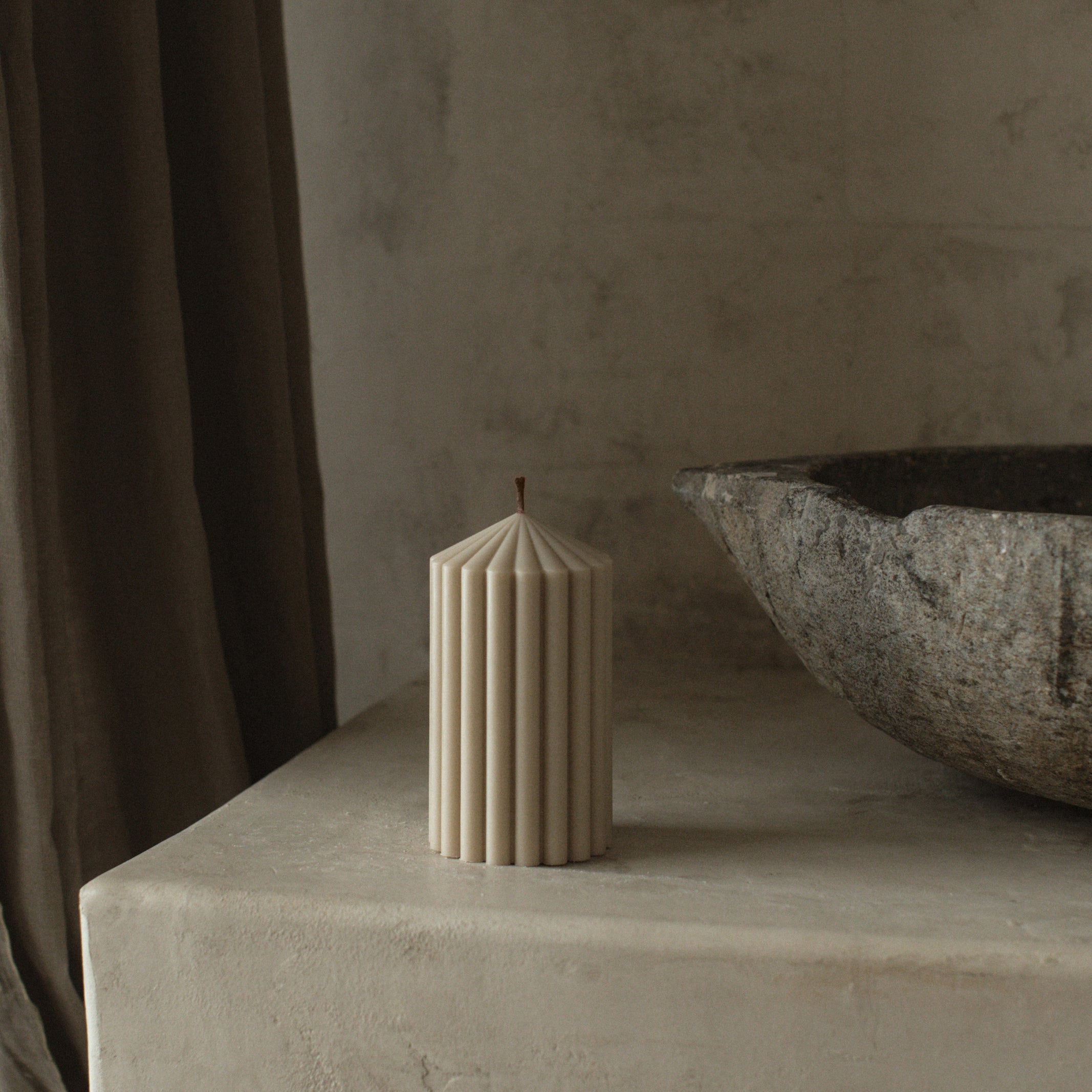 LAWA small moon gray soy wax peak candle featuring a clean geometric peak design on a stone surface with a textured wall and curtain in the background