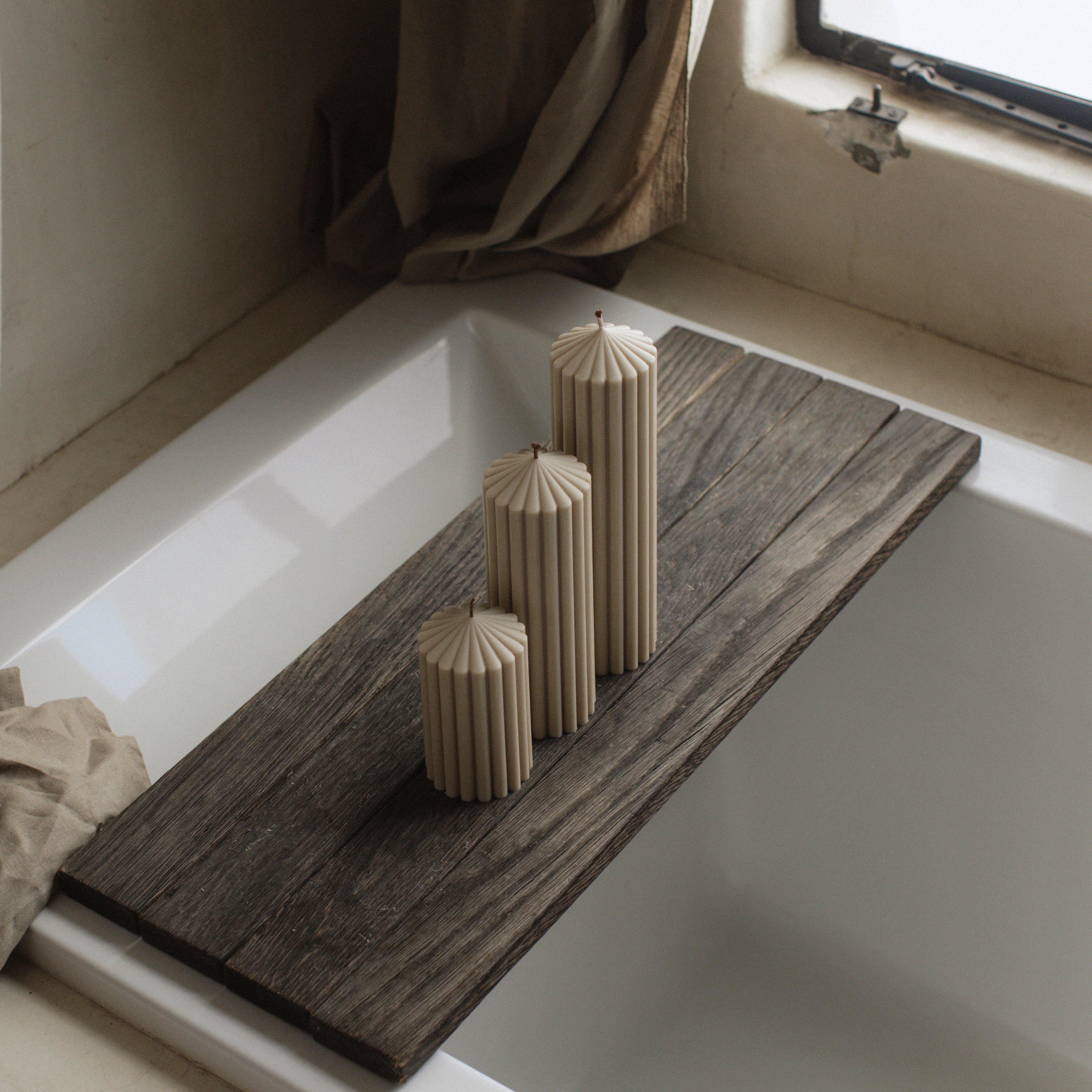 Moon gray soy wax peak pillar candle set of 3 by LAWA with geometric pointed design on a bathtub ledge