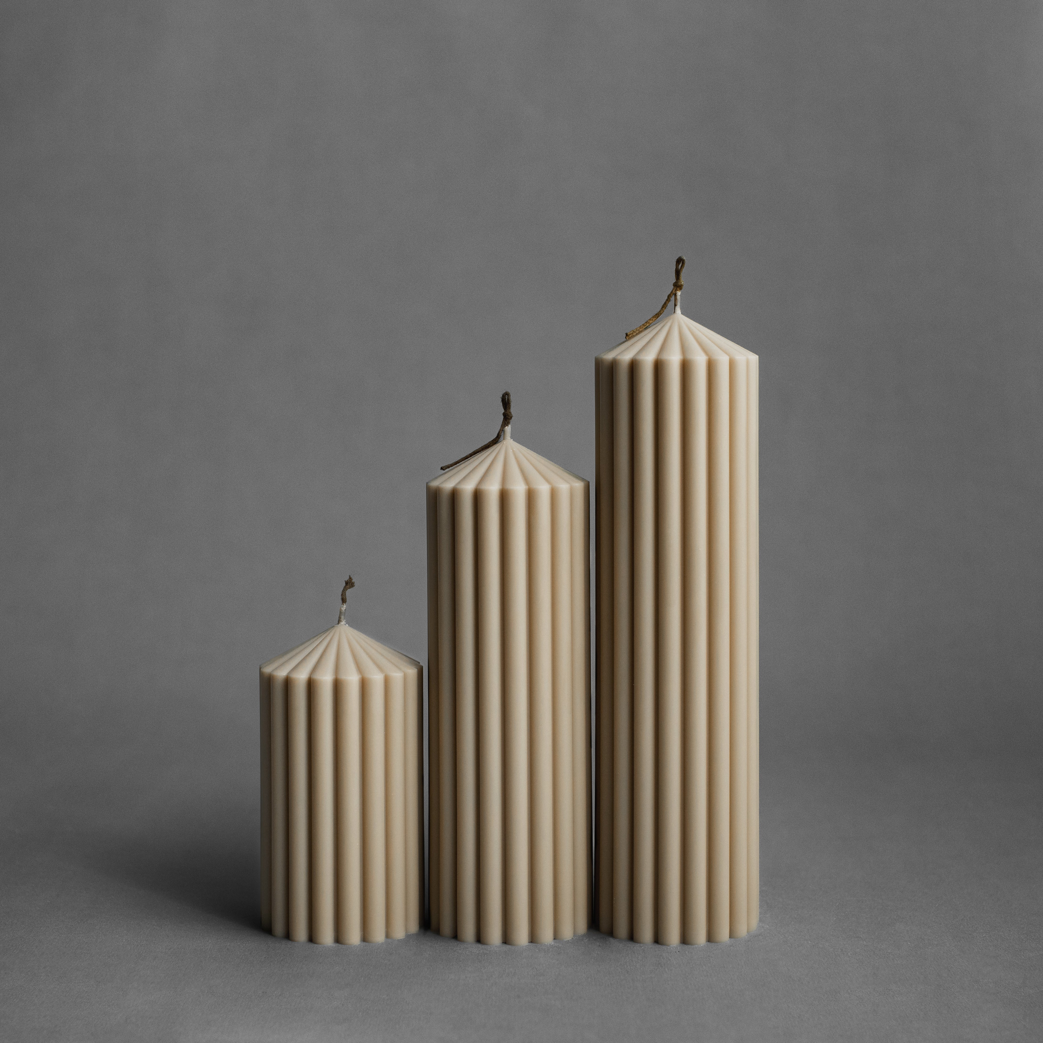 Set of three sandstone peak pillar candles by LAWA in small, medium, and large sizes