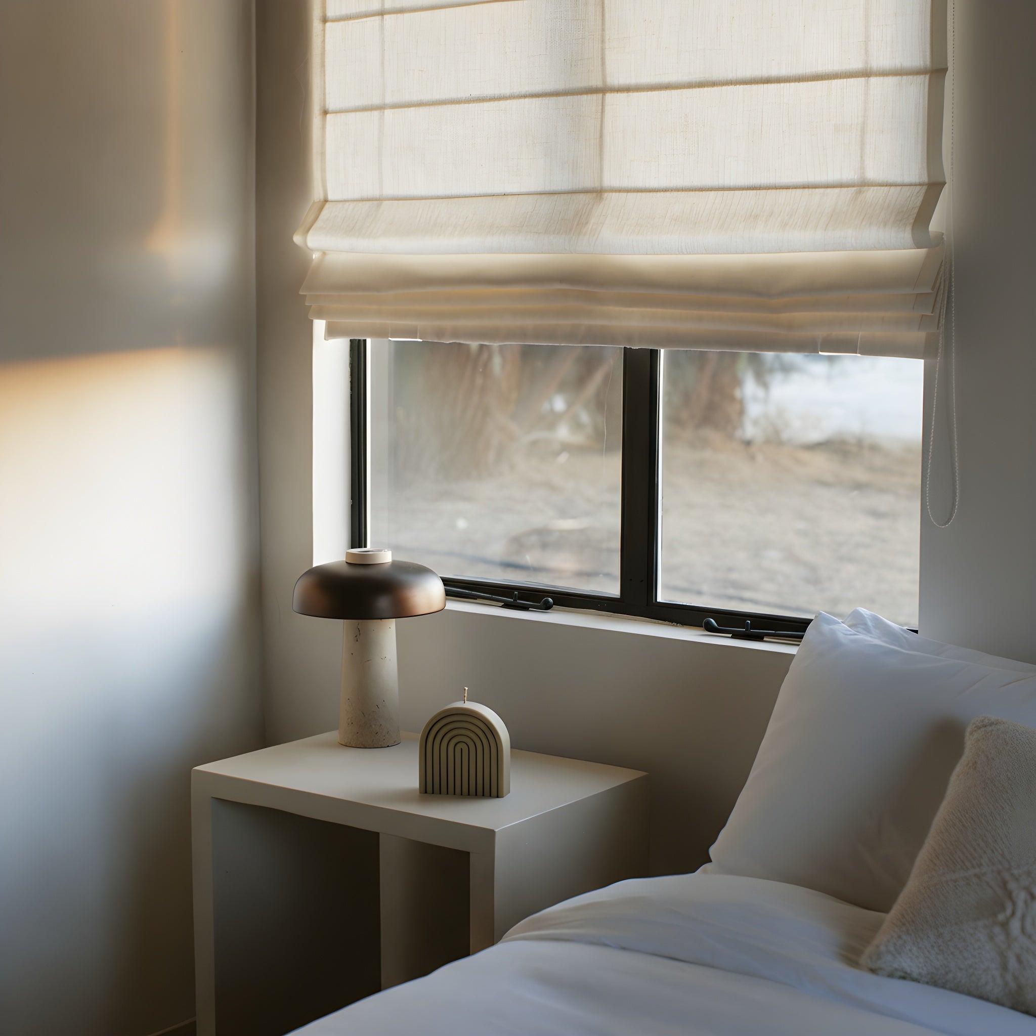 Neutral olive beige rainbow candle by LAWA in soy wax in a Bedroom with a window, nightstand, and lamp