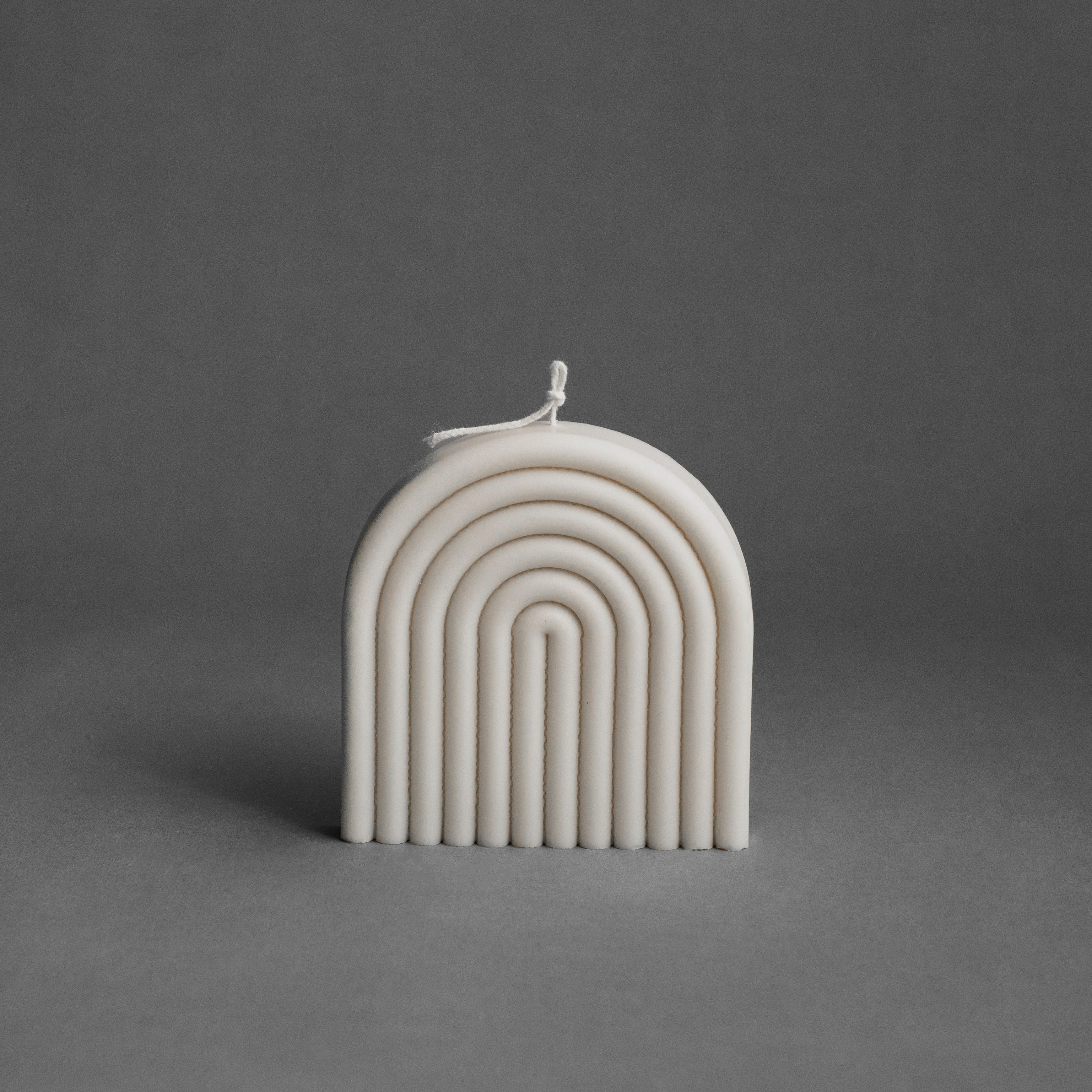 White rainbow pillar candle by LAWA with soft arch-inspired lines