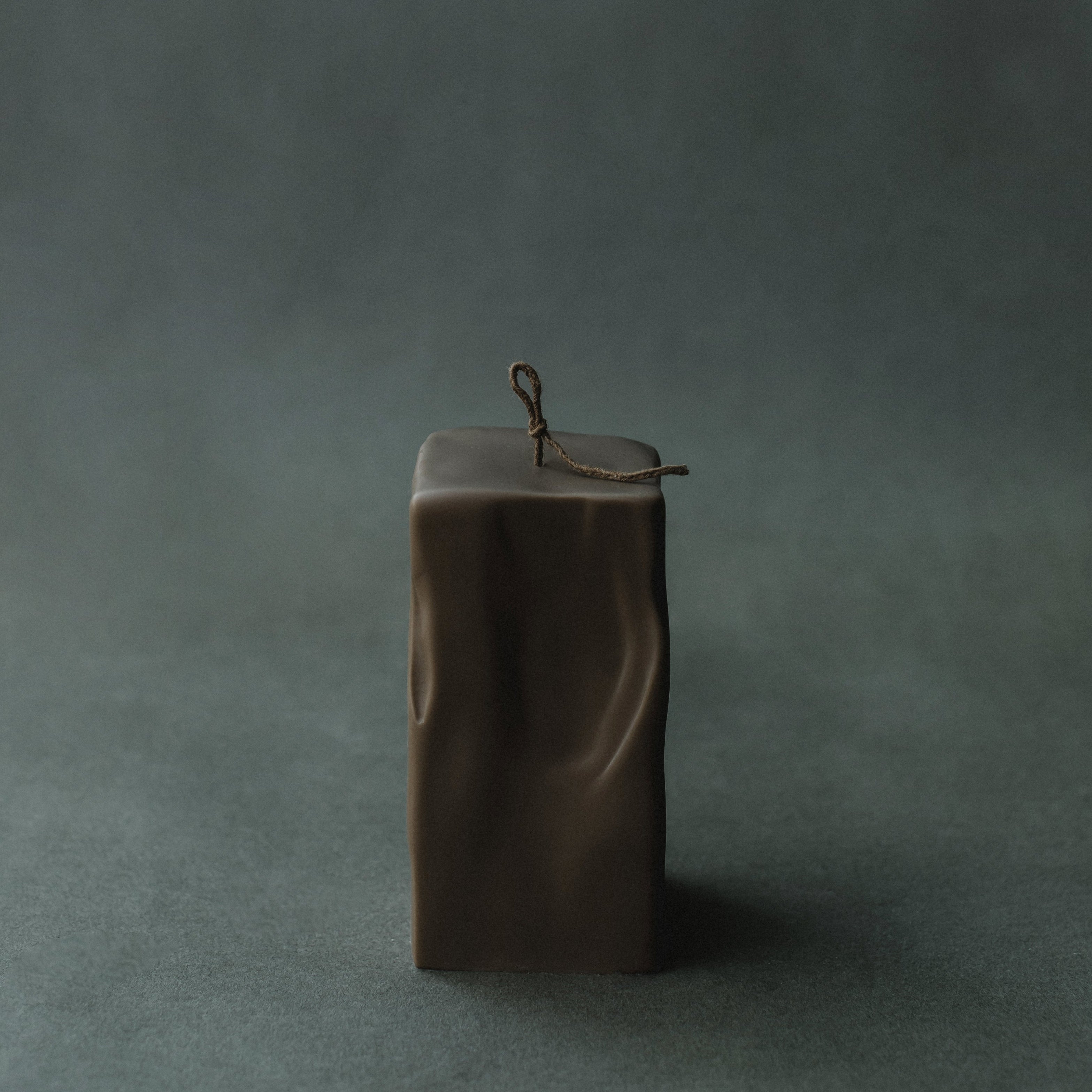LAWA large kobicha soy wax raw block candle on a dark green background