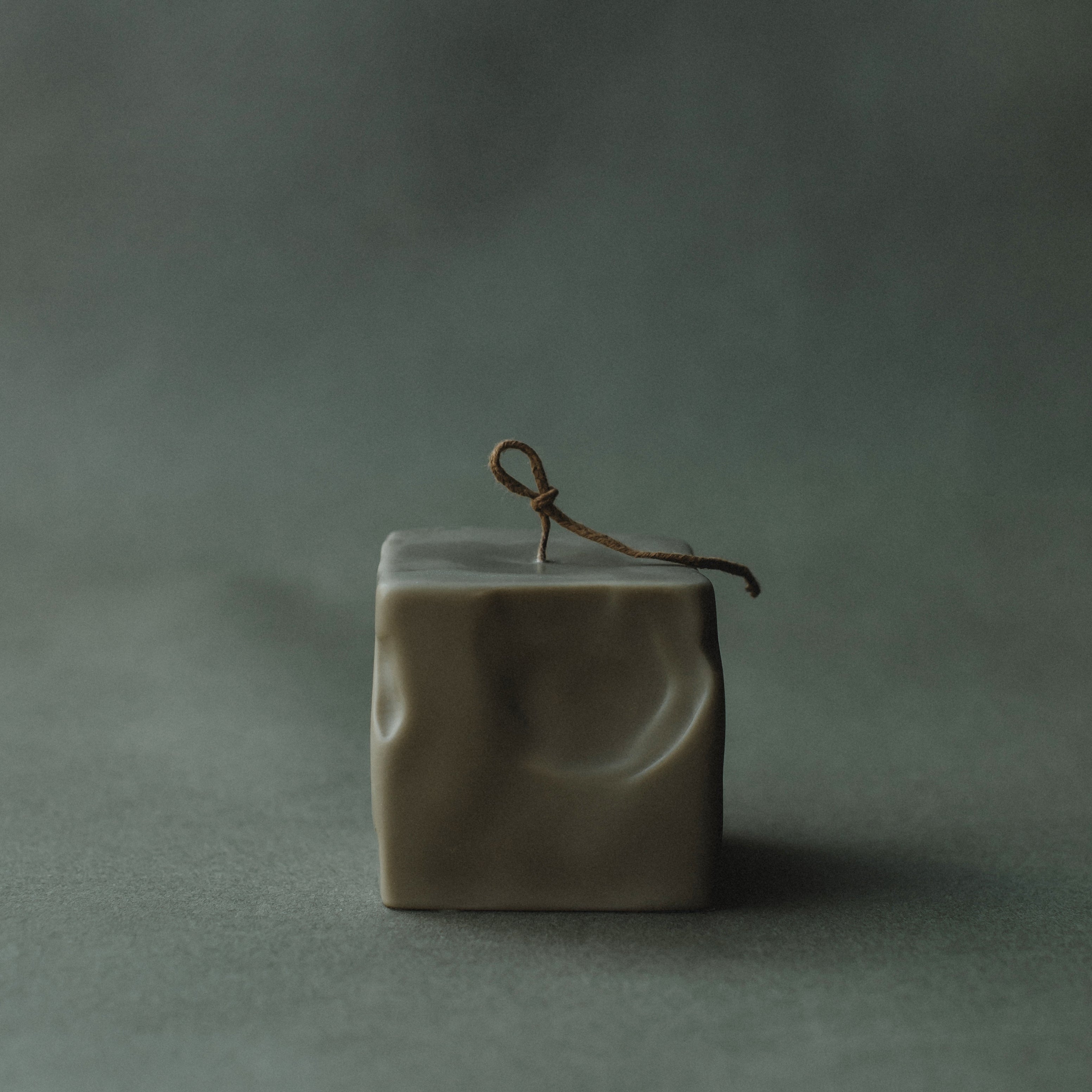 Small earthy green raw block candle by LAWA with modern sculptural geometry