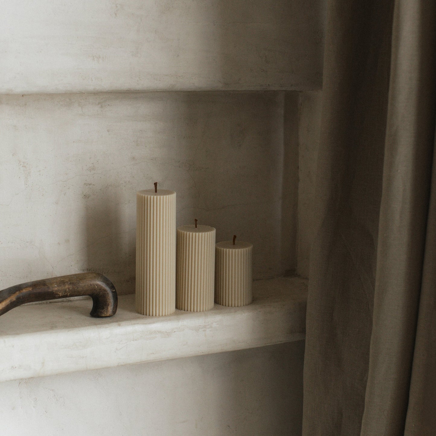 Close-up detail of handmade ribbed sculptural candle showing textured soy wax surface and natural cotton wick