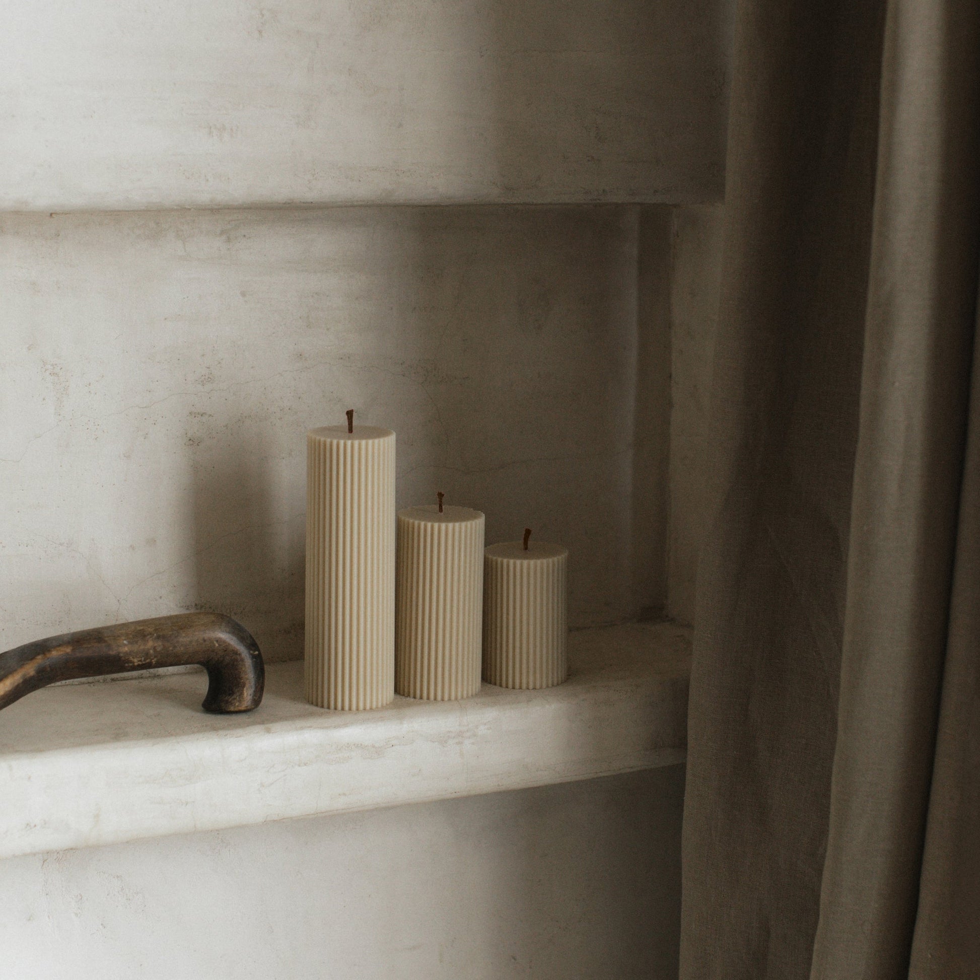 Close-up detail of handmade ribbed sculptural candle showing textured soy wax surface and natural cotton wick