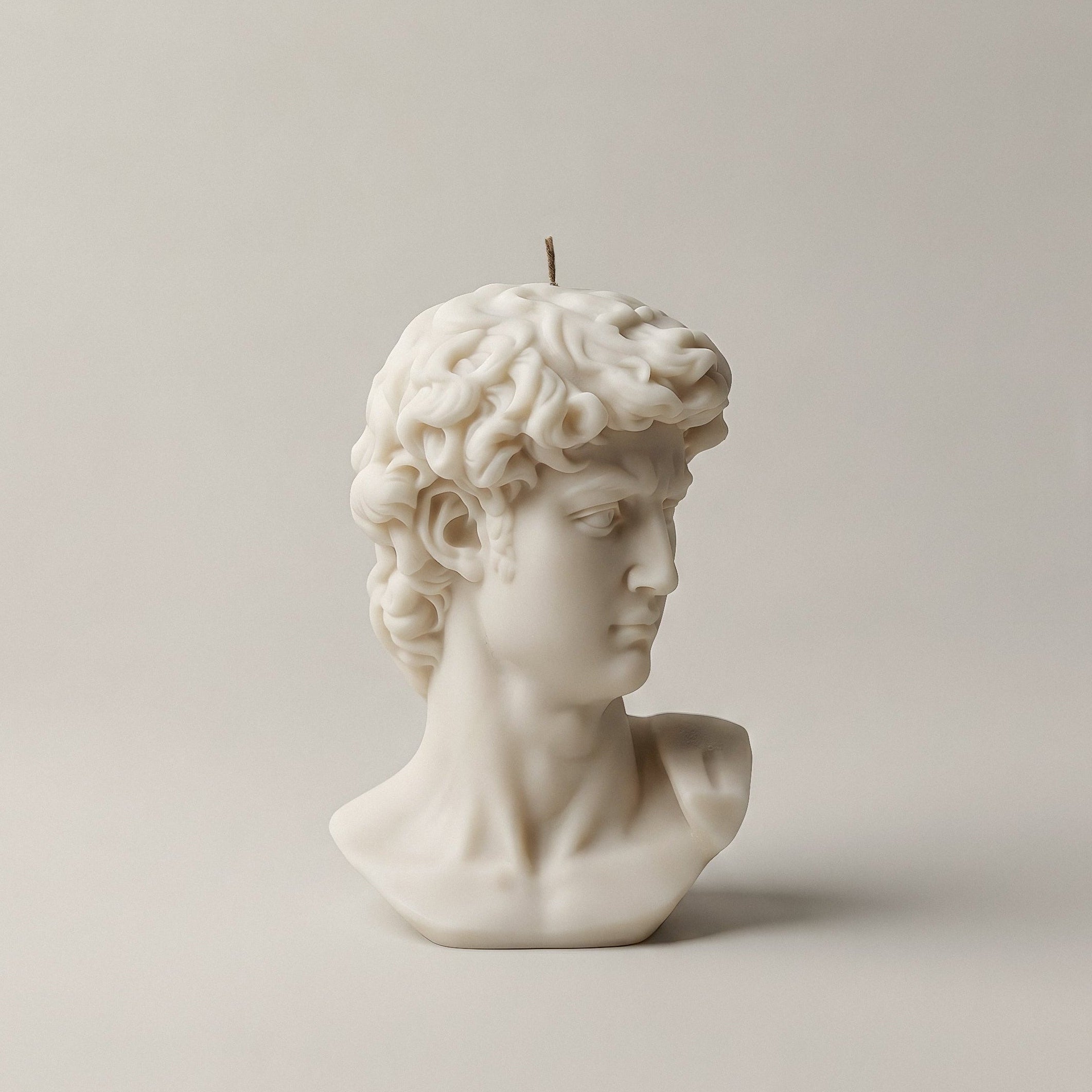 White unscented sculptural candle shaped like the David bust, handmade from premium soy wax in Los Angeles