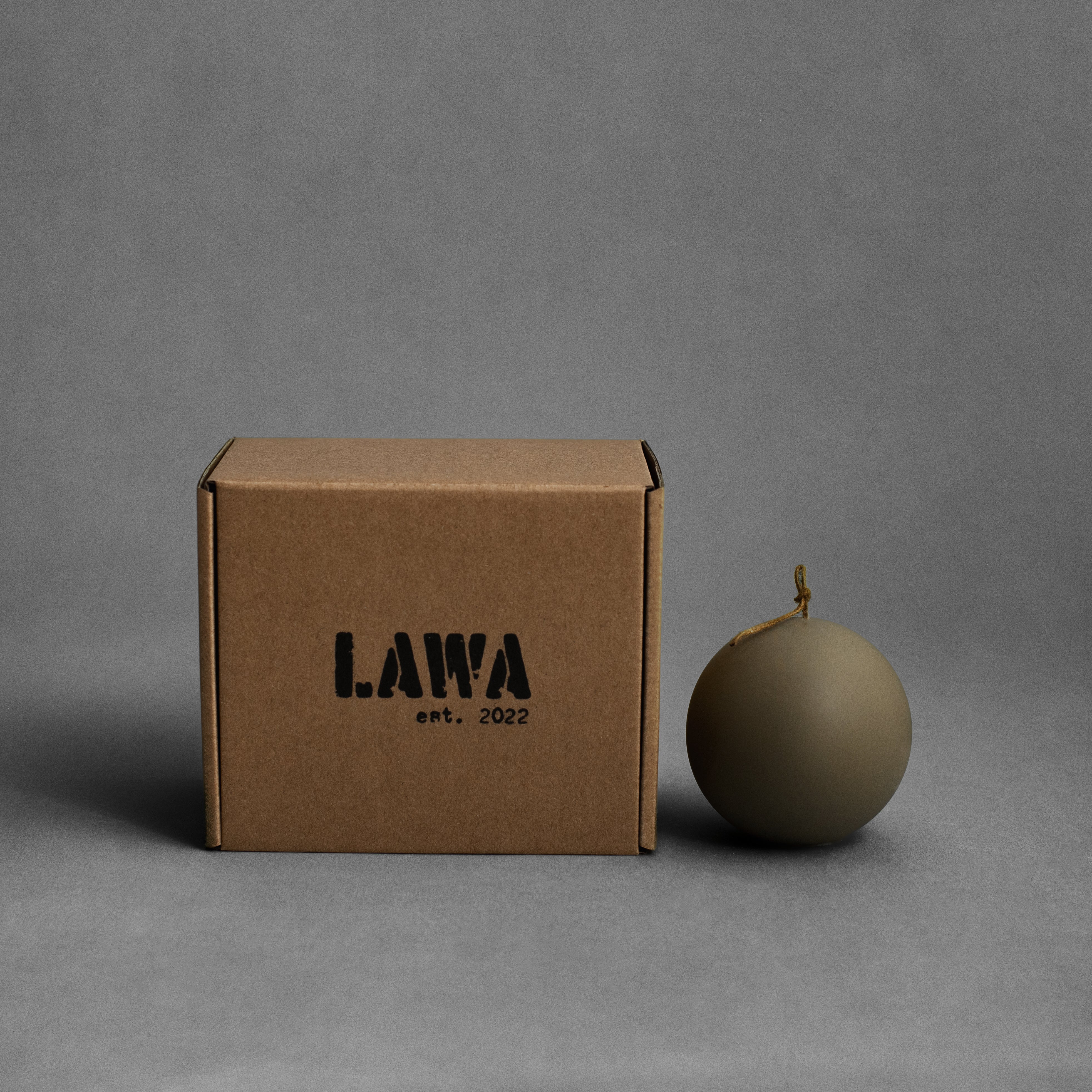 Small earthy green sphere soy wax pillar candle by LAWA with smooth rounded sculptural form with box