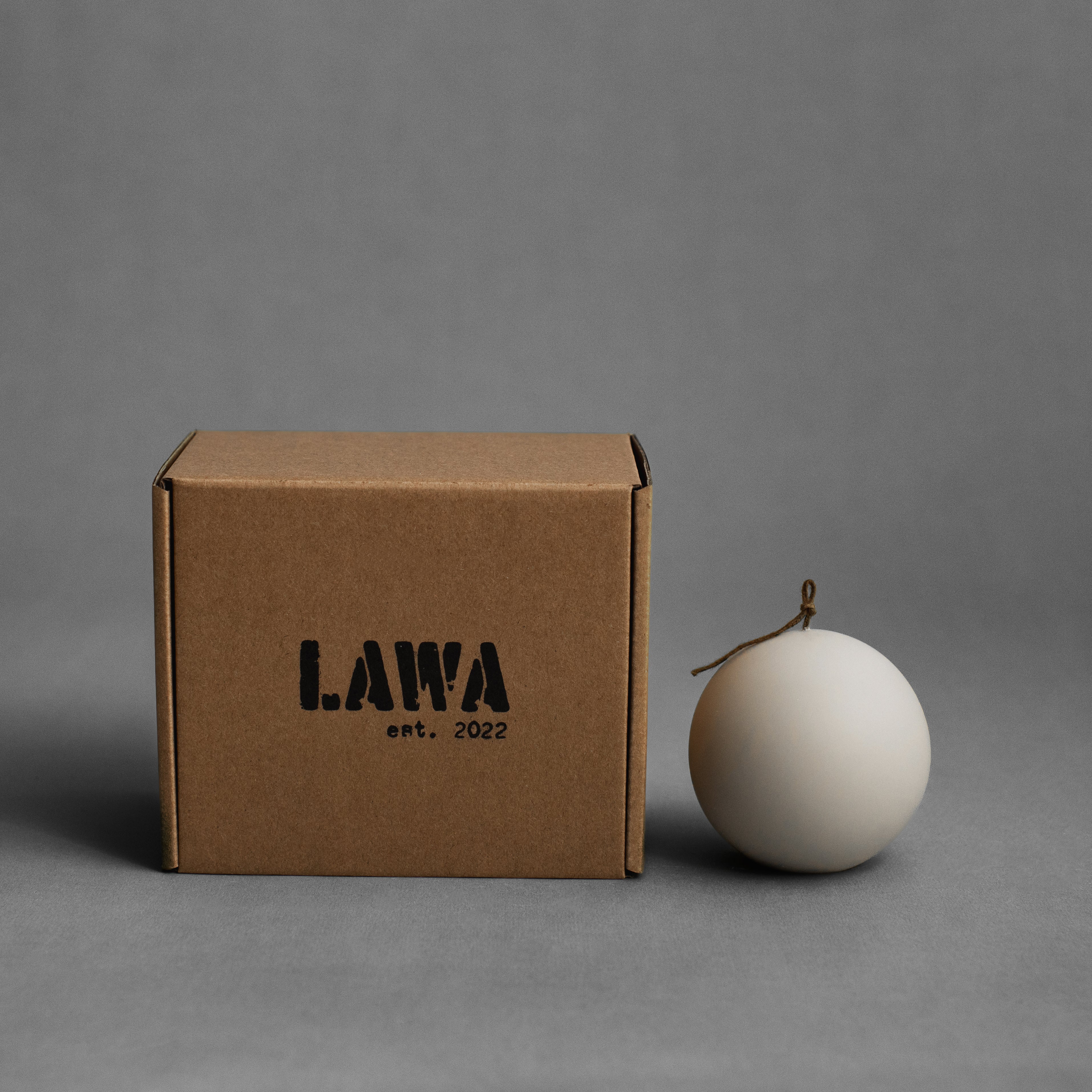Small light beige sphere soy wax pillar candle by LAWA with smooth sculptural round shape for minimalist styling