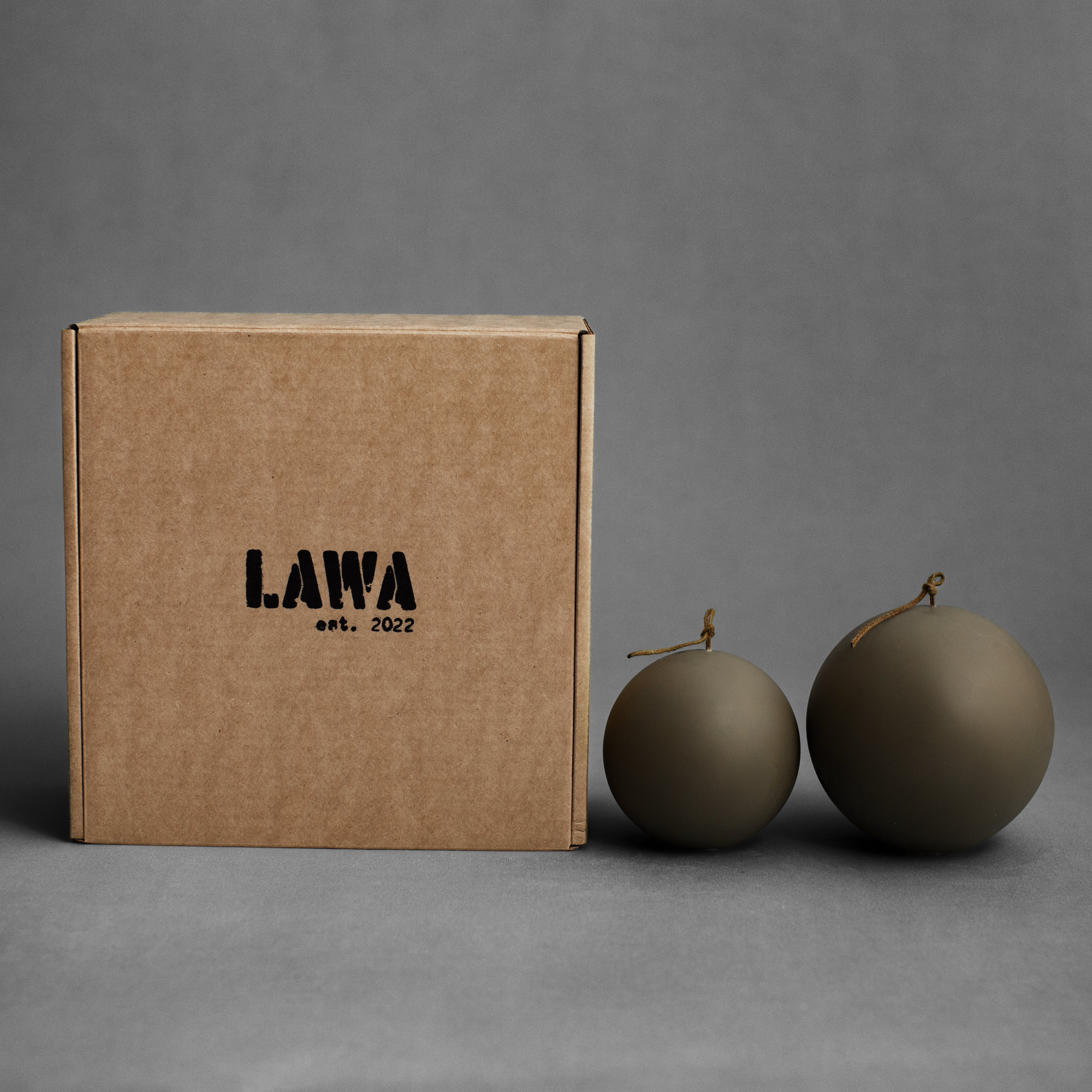 Earthy green sphere pillar candle set by LAWA with sculptural rounded shapes for modern natural decor with packaging box
