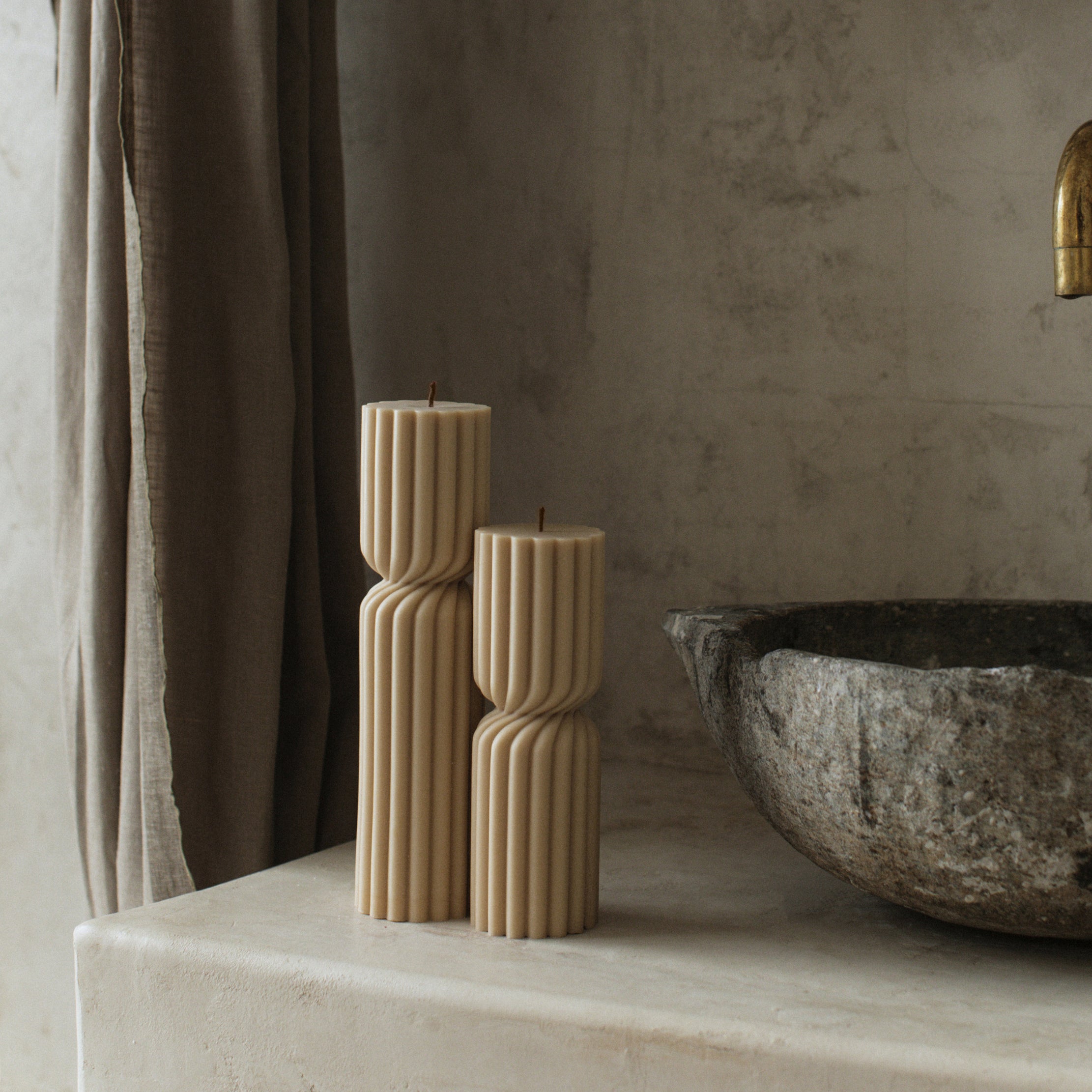 Sandstone spiral pillar candle duo by LAWA with textured spire silhouette