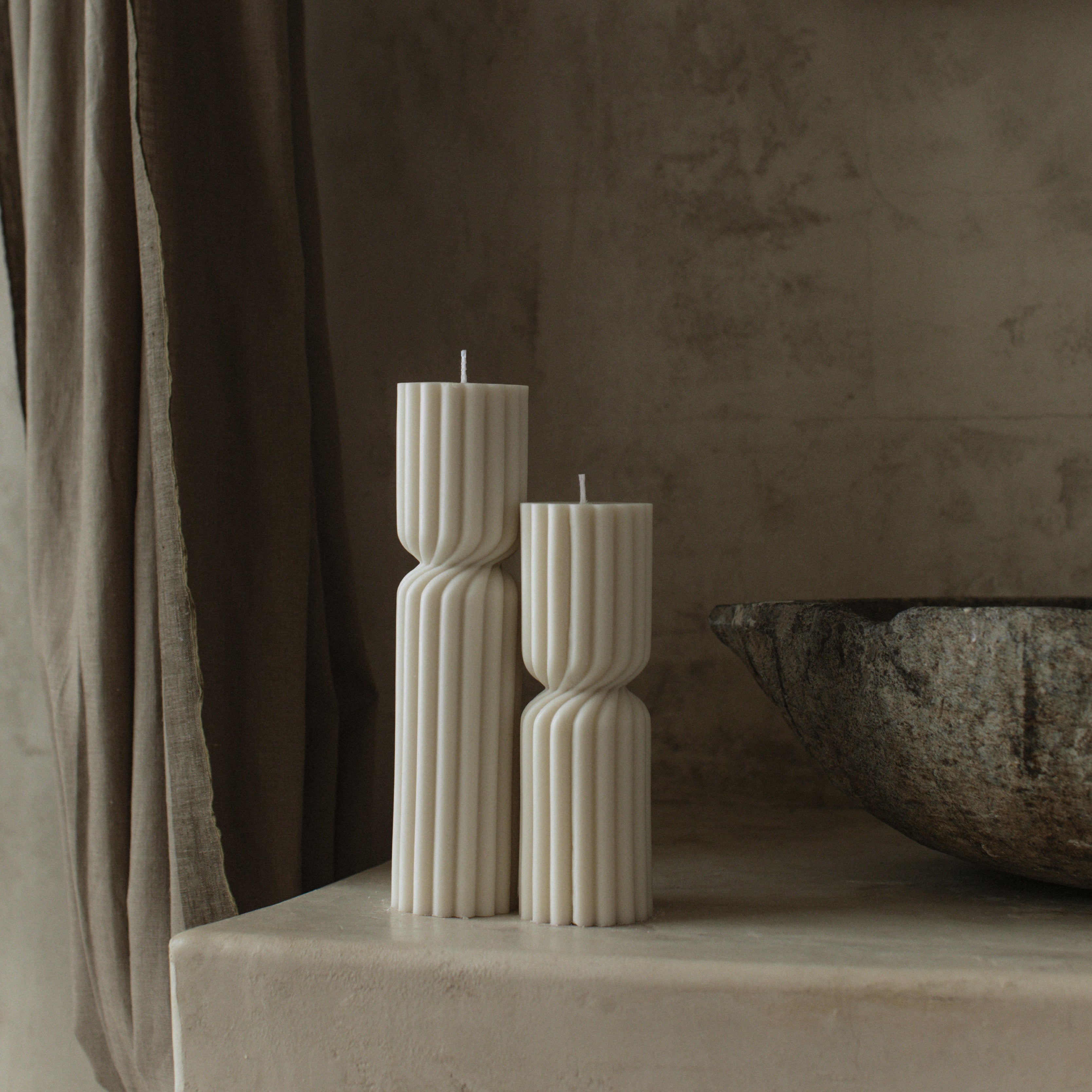 White twisted spire pillar candle set by LAWA on a stone surface with a neutral background