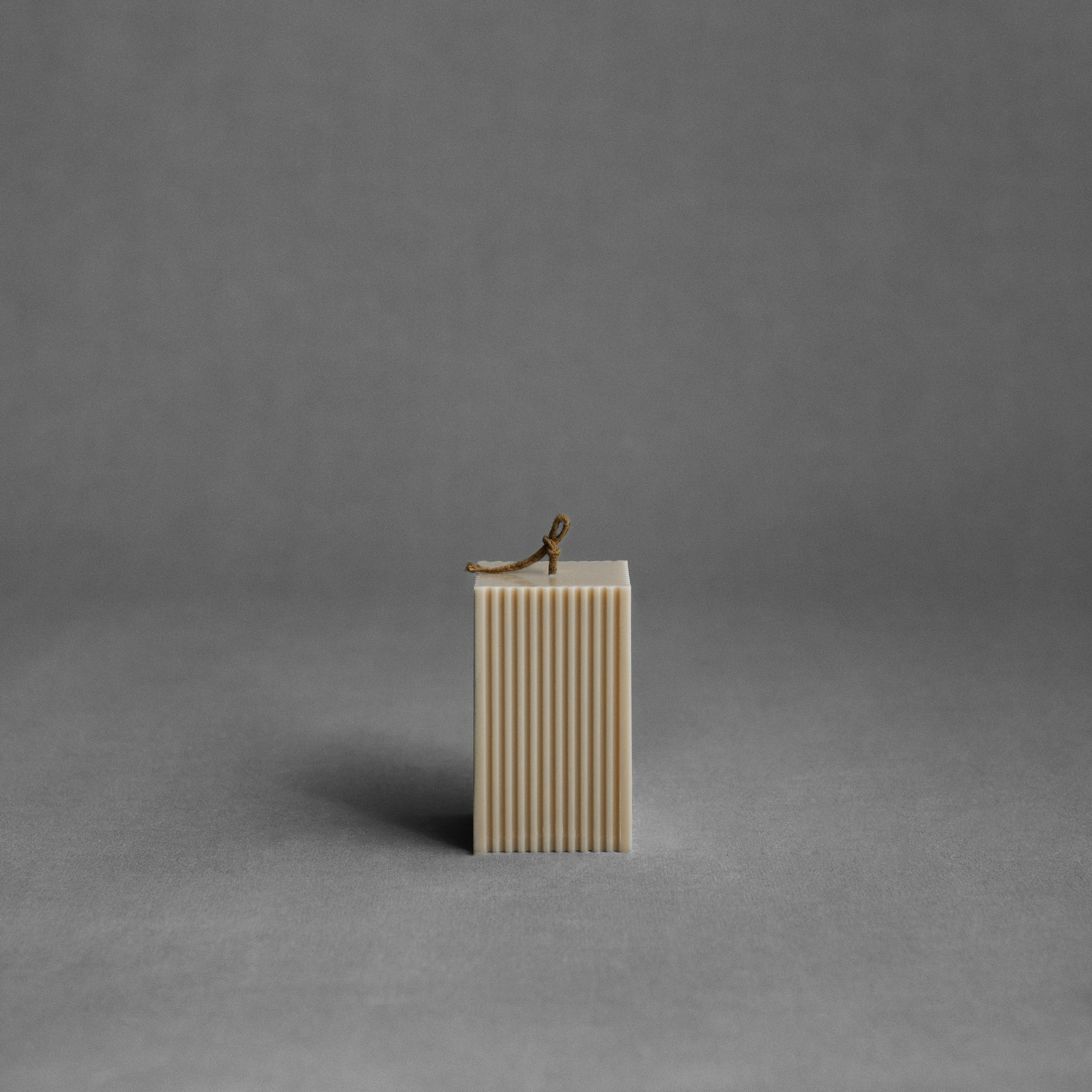 Sandstone square ribbed pillar candle by LAWA with warm-toned vertical texture