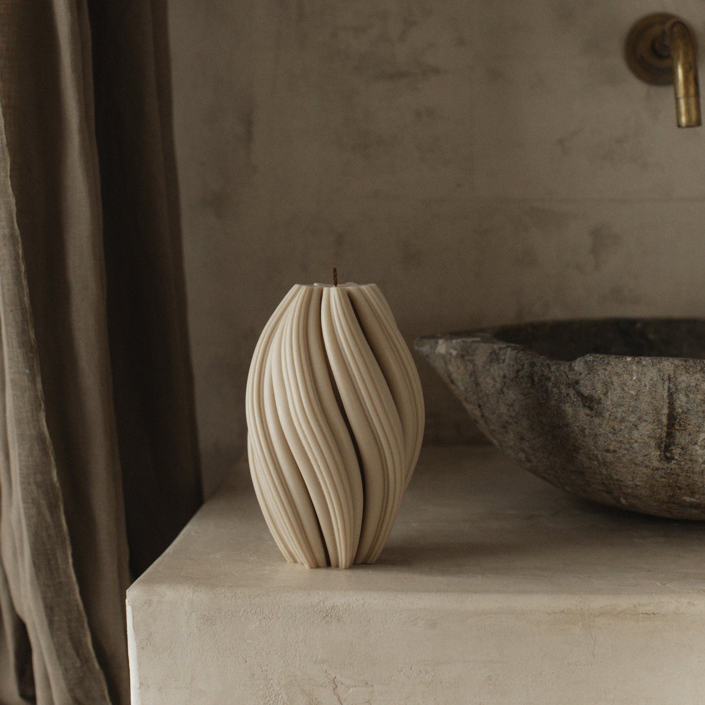 Detail of handmade soy wax swirl sculptural candle showing organic texture and curves in natural light