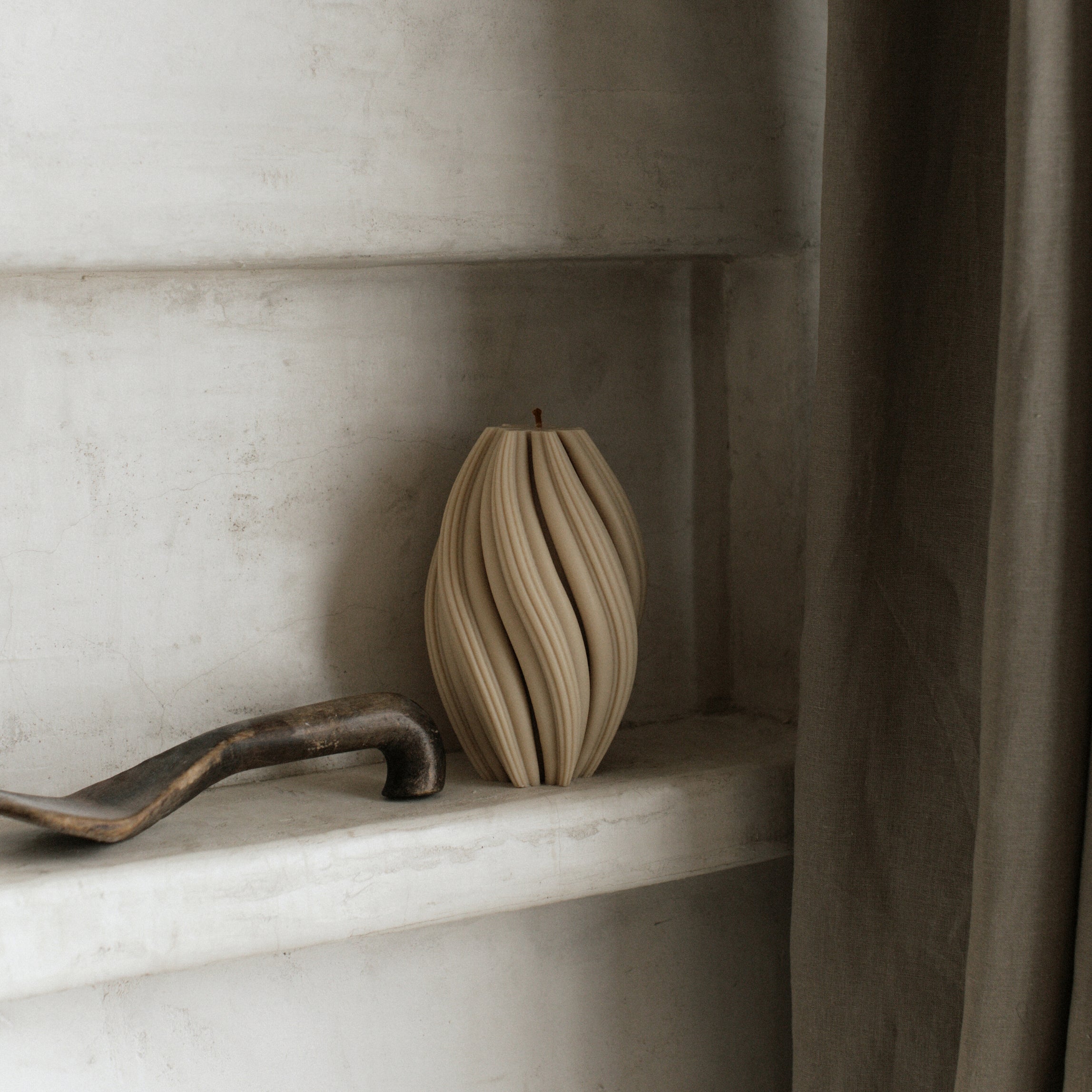 LAWA large sandstone swirl candle featuring tall twisted spiral texture on a shelf with a neutral background