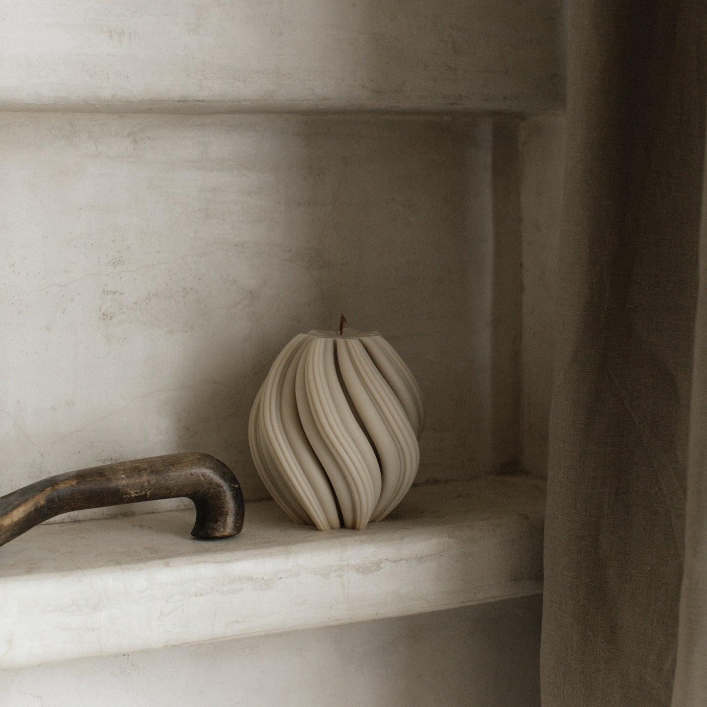 Close-up detail of handmade soy wax swirl candle texture showing smooth sculptural curves and premium finish