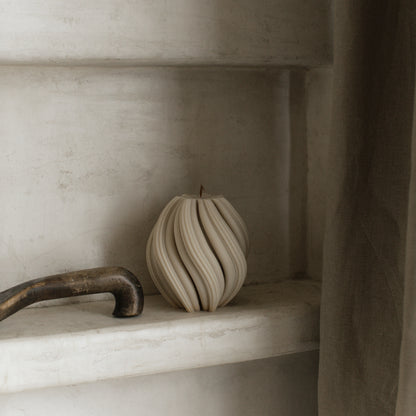Close-up detail of handmade soy wax swirl candle texture showing smooth sculptural curves and premium finish
