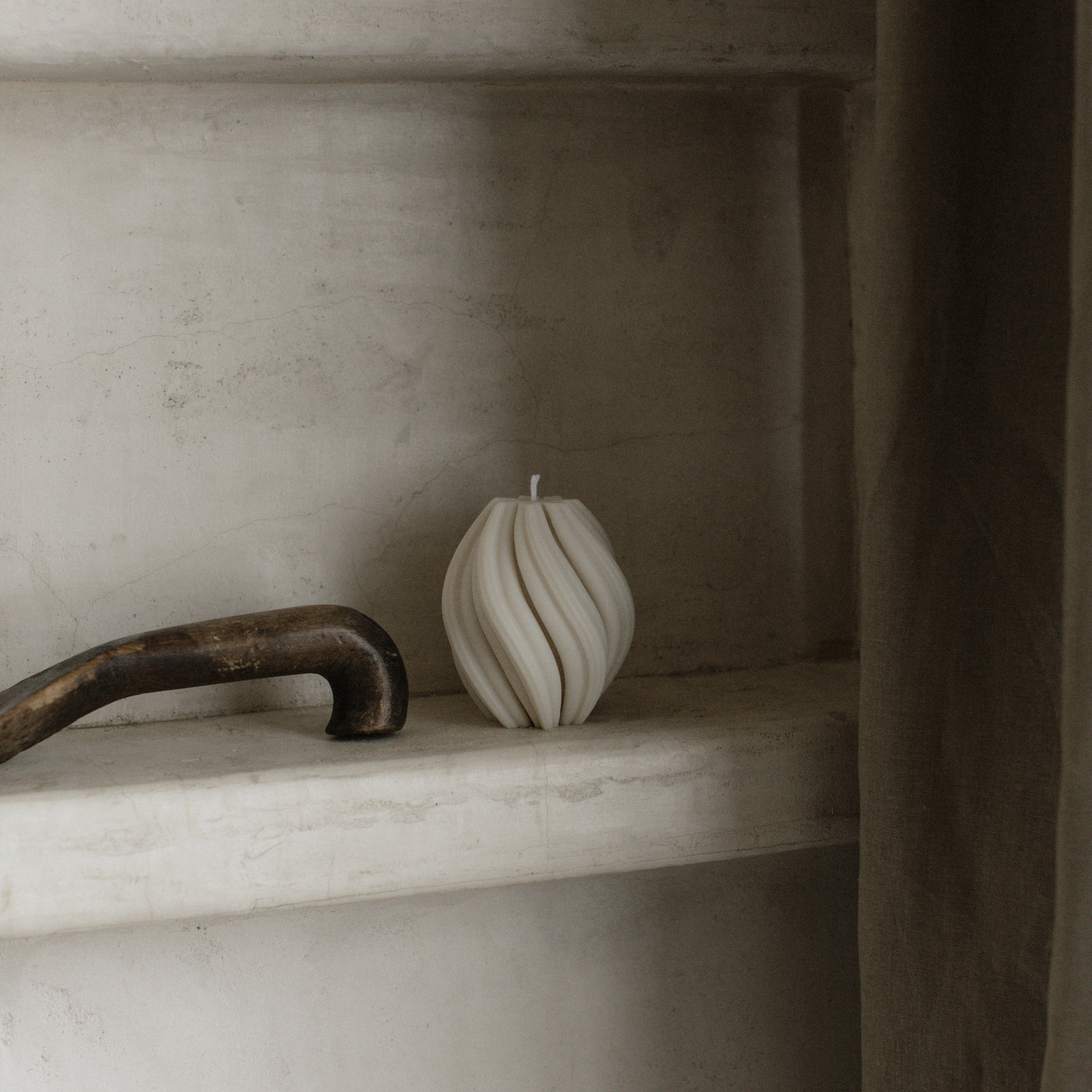 LAWA small white swirl candle featuring clean twisted spiral texture on a stone shelf with a rustic handle.