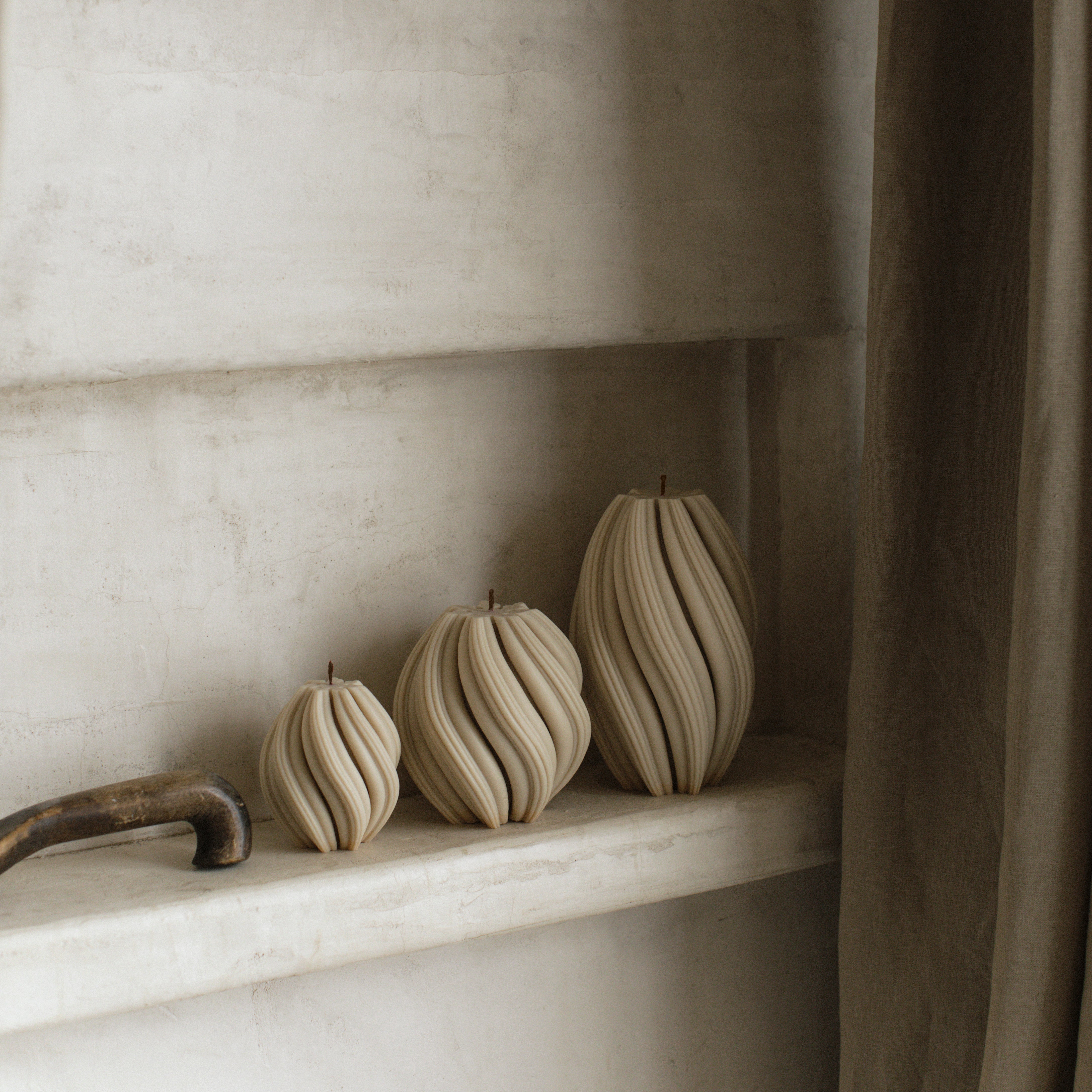 Moon gray soy wax swirl candle set of 3 by LAWA with coordinated spiraling designs on a marble shelf against a neutral wall.