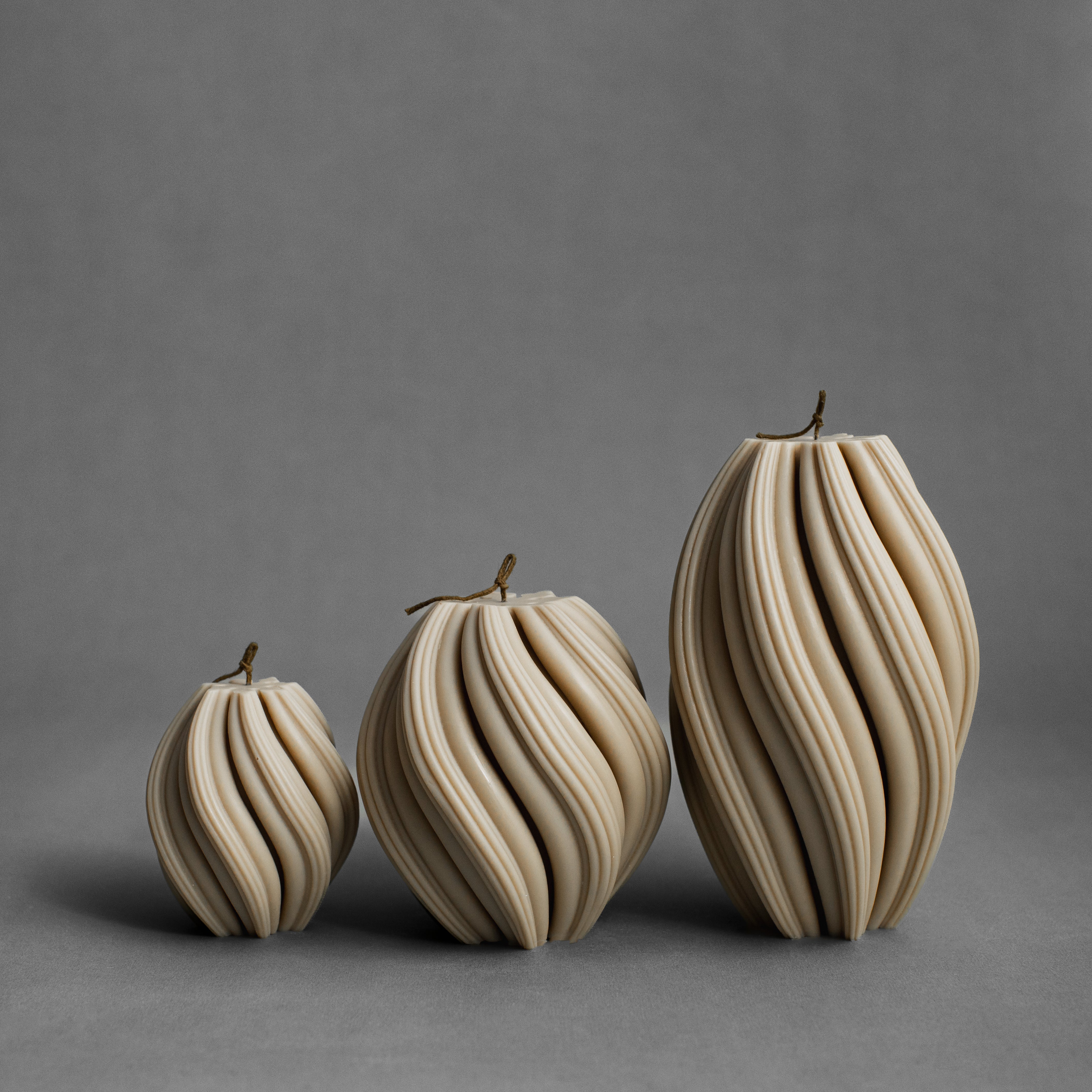 Set of three sandstone swirl pillar candles by LAWA in small, medium, and large