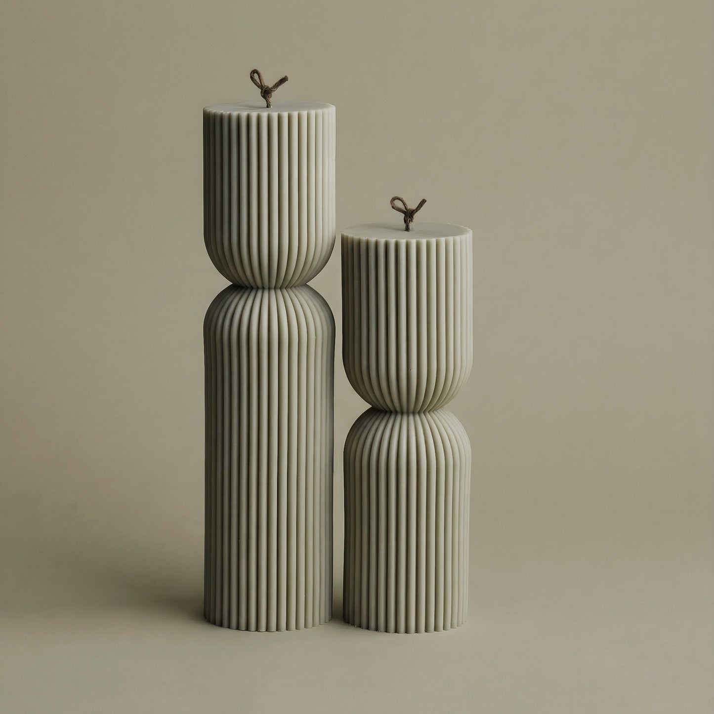 Close-up detail of handmade hourglass sculptural candle showing smooth soy wax texture and cotton wick