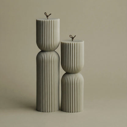 Close-up detail of handmade hourglass sculptural candle showing smooth soy wax texture and cotton wick