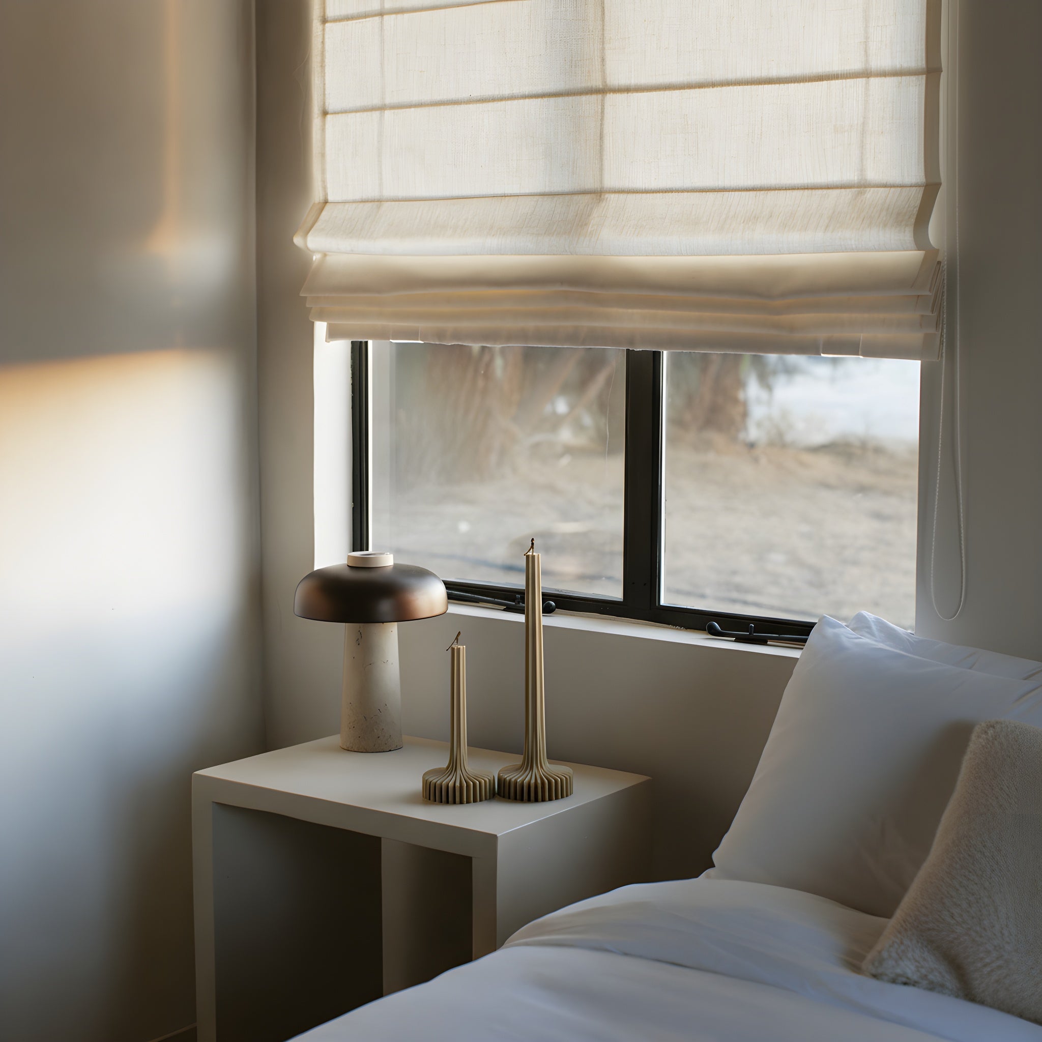 Earthy olive beige vase candle set by LAWA with smooth minimalist silhouettes in the bedroom with a window, nightstand, and decorative items.