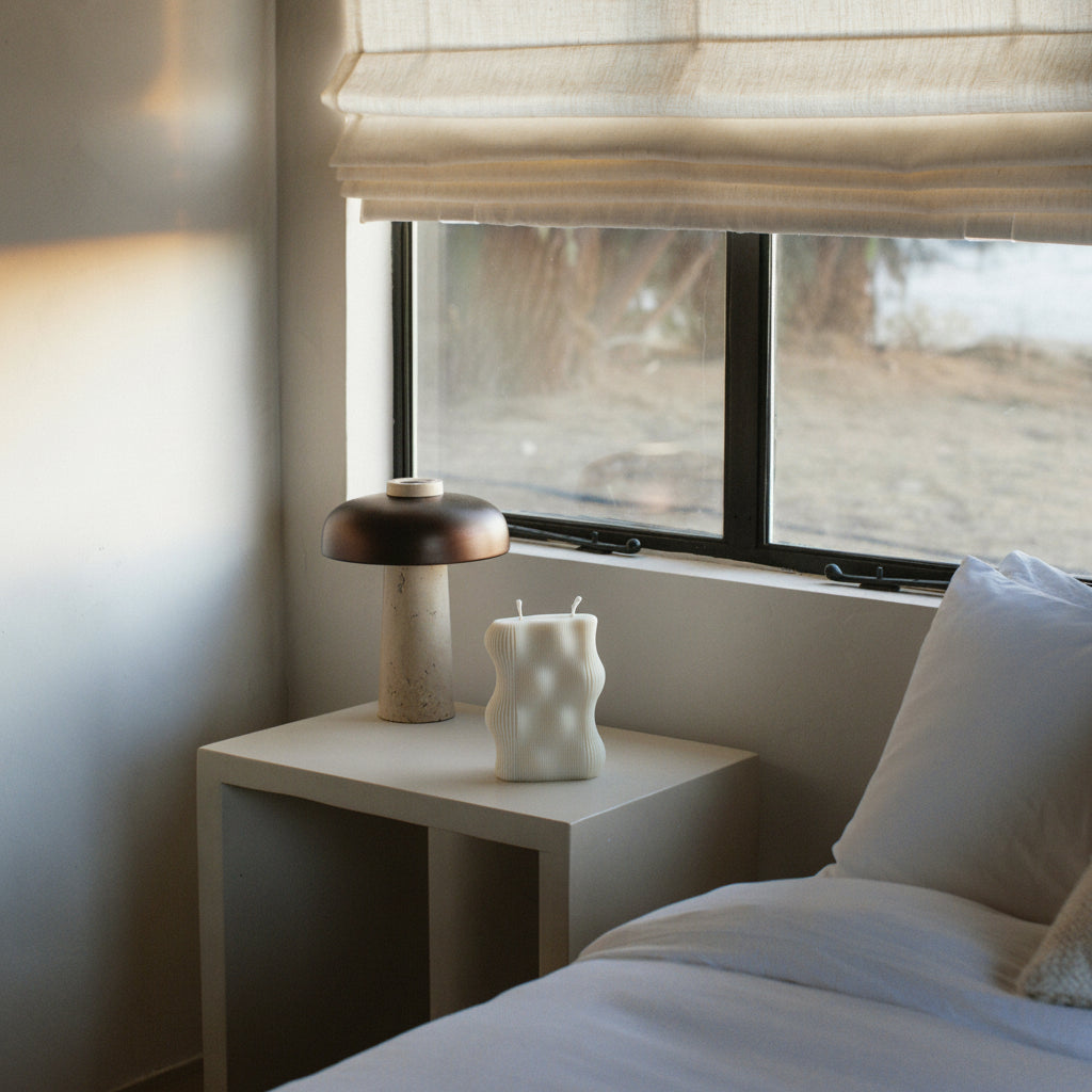 White wavy ribbed candle in the bedroom