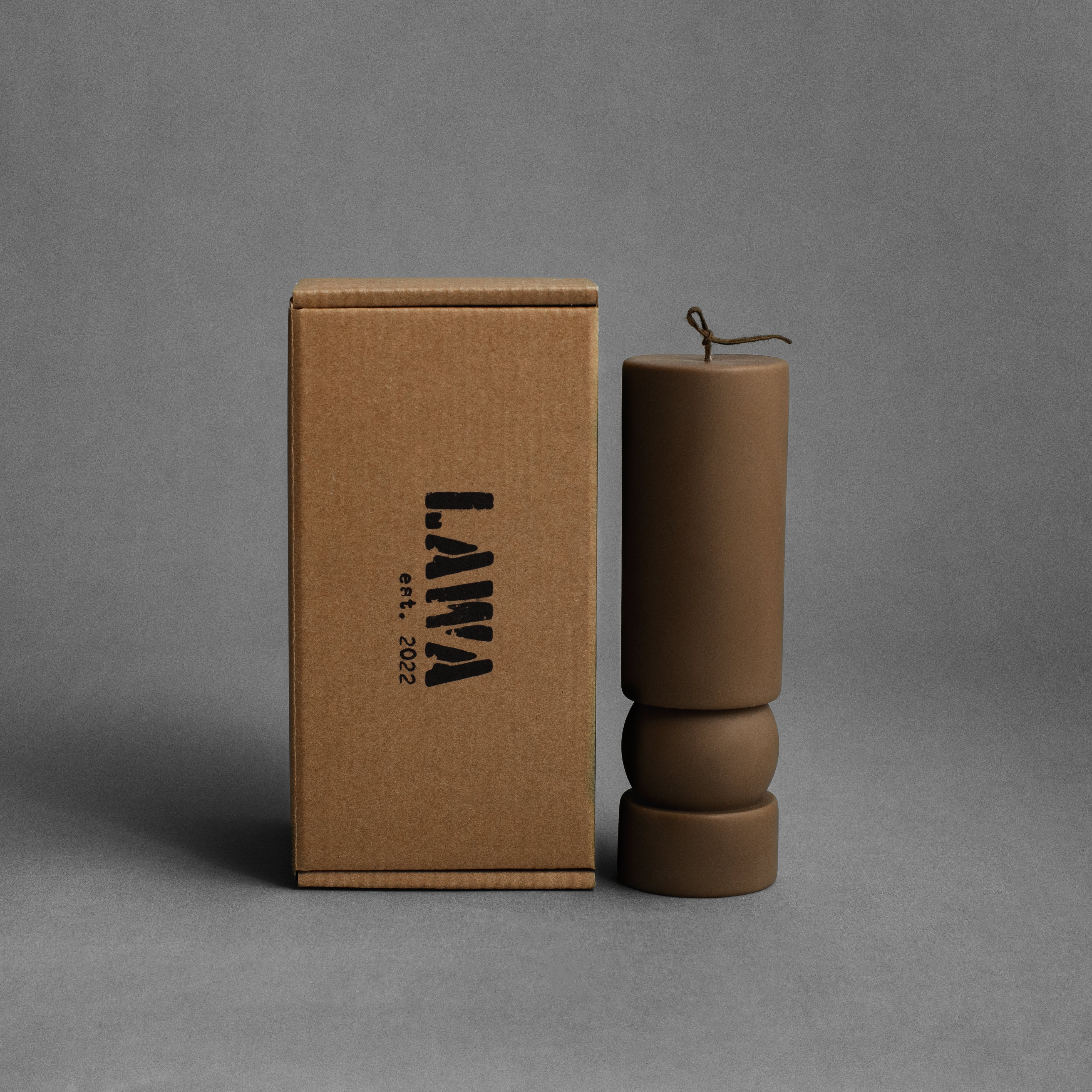 Kobicha brown Zen sculptural soy wax candle by LAWA with a smooth pillar shape for warm modern decor, with the box used for packaging 